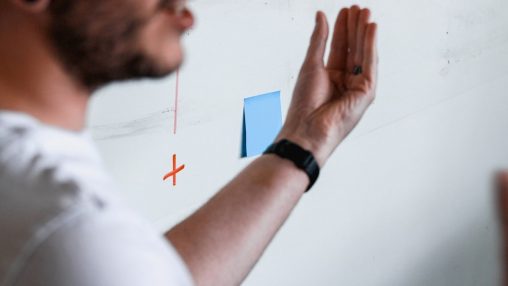 a man drawing a diagram on a white board